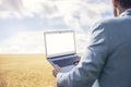 Business in nature out of office blank laptop screen in wheat field