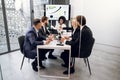 Business negotiations in office room. Team of attractive successful international corporate workers, sitting at the Royalty Free Stock Photo