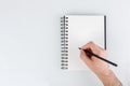 business notepad, hand holding a pencil on a white background