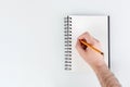 business notepad, hand holding a pencil on a white background