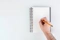 business notepad, hand holding a pencil on a white background