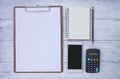 Business object concept, New smartphone and blank notebook with blank paper on wooden clipboard Royalty Free Stock Photo