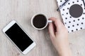 Business and office concept - black and white polka dot cover notebook, smartphone and cup of black coffee on wooden table. top Royalty Free Stock Photo