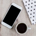 Business and office concept - black and white polka dot cover notebook, smartphone and cup of black coffee on wooden table. top Royalty Free Stock Photo