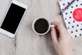 Business and office concept - black and white polka dot cover notebook, smartphone and cup of black coffee on wooden table. top Royalty Free Stock Photo