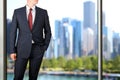 Business and office concept - elegant young fashion buisness man in a blue/navy suit. Downtown background behind