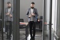 Business and office lifestyle. Bearded man look out room door. Businessman in modern office with glass walls. Confident Royalty Free Stock Photo