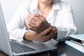 A business office worker is an asian woman is sitting in front of the laptop computer. A businesswoman stressing her body part Royalty Free Stock Photo