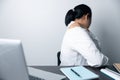 A business office worker is an asian woman is sitting in front of the laptop computer. A businesswoman stressing her body part Royalty Free Stock Photo