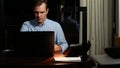 Business, overwork, deadline and concept of people - a man working on a laptop at night. Royalty Free Stock Photo