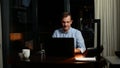 Business, overwork, deadline and concept of people - a man working on a laptop at night. Royalty Free Stock Photo