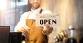 Business owner attractive young Asian man in apron hanging we`re open sign on front door  welcoming clients to new cafe. Happy Royalty Free Stock Photo