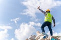 A business owner raised a glass bottle with success and holding a tablet on top of the recycling bin at recycling plant