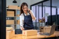 Business owner talking on mobile phone and taking order. Female asian entrepreneur working at home office confirming the Royalty Free Stock Photo