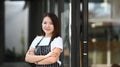 A business owner woman standing with arms crossed and smiling to camera at her coffee shop. Royalty Free Stock Photo