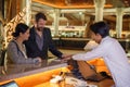 Business partners or colleagues doing check in at the hotel. Young couple and receptionist at counter in hotel