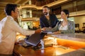 Business partners or colleagues doing check in at the hotel. Young couple and receptionist at counter in hotel