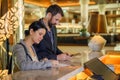 Business partners or colleagues doing check in at the hotel. Young couple and receptionist at counter front desk filling