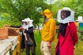 Business partners with an experienced senior beekeeper checking the quality and production of honey at a large bee farm Royalty Free Stock Photo