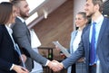 Business partners handshaking over business objects on workplace Royalty Free Stock Photo