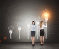 Business partners, light bulb torches, blackboard Royalty Free Stock Photo