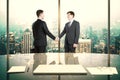 Business partners shake hands in modern office with night megapolis city view