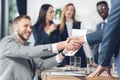 business partners shaking hands with blurred colleagues Royalty Free Stock Photo