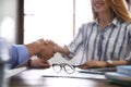 Business partners shaking hands at table after meeting in office Royalty Free Stock Photo