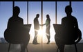 Business partners silhouettes shaking hands