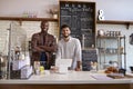 Business partners stand behind the counter at a coffee shop Royalty Free Stock Photo