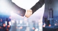 Business partnership and agreement concept with handshaking of two businessmen and blurry city on background Royalty Free Stock Photo