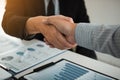 Business partnership shaking hands for signing company financial statements report and profits earned during years in office room Royalty Free Stock Photo