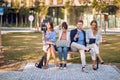 Business people on bench at park,working on laptop,texting message.. Young employees outdoor