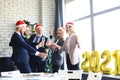Business people are celebrating holiday in modern office drinking champagne and having fun in coworking. Merry Christmas Royalty Free Stock Photo