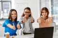 Group of businesswomen showing thumbs up at office