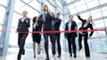 Business people crossing red ribbon finish line Royalty Free Stock Photo