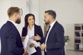 Business people discuss contract to work together during meeting in modern office.