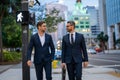 Business people discuss a project. Two young businessmen outdoors city looking cityscape. Businessmen communicating at Royalty Free Stock Photo