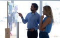 Business people discussing over graph on glass wall in a modern office Royalty Free Stock Photo
