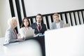 Business people discussing while sitting at desk in seminar hall Royalty Free Stock Photo