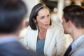 Business people, discussion or meeting in office for corporate project or collaboration on work. Mature woman, young man Royalty Free Stock Photo