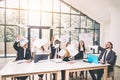 Business people excited happy smile, throw papers, documents fly in air, businesspeople sitting at office desk hold Royalty Free Stock Photo