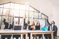 Business people excited happy smile, throw papers, documents fly in air, businesspeople sitting at office desk hold Royalty Free Stock Photo