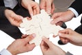 Business people fixing jigsaw pieces