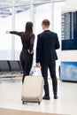 Business people in formal clothing walking with wheeled bags at airport terminal Royalty Free Stock Photo