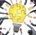 Business People Forming a Light Bulb Puzzle