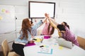 Business people giving high-five together in meeting at creative office Royalty Free Stock Photo