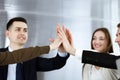 Business people group showing teamwork and joining hands or giving five in modern office. Unknown businessman and women