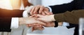 Business people group showing teamwork and joining hands or giving five in sunny office. Unknown businessman and women