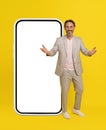 Business people, handsome middle aged businessman stand in front big smartphone with white screen spread hands. Man in Royalty Free Stock Photo